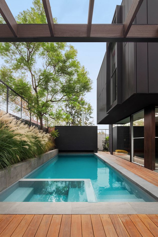 an outdoor swimming pool in the middle of a backyard with trees and plants on either side