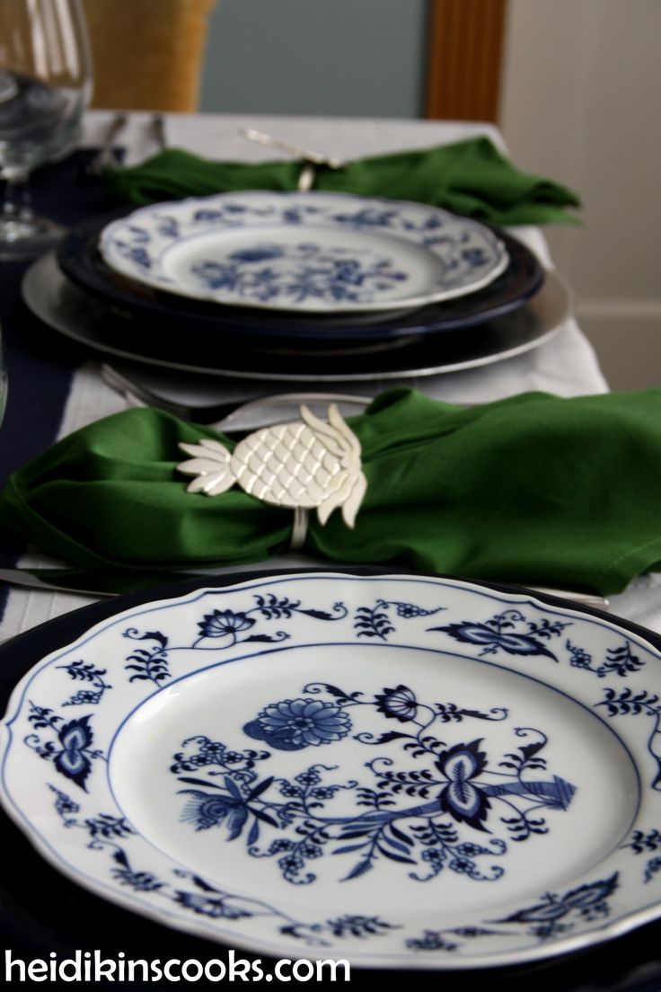 the table is set with blue and white plates, green napkins, and silverware