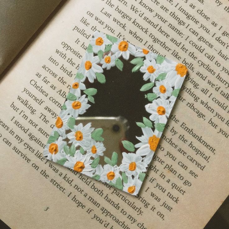 an open book with some flowers on it