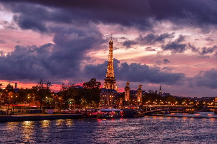 the eiffel tower is lit up at night