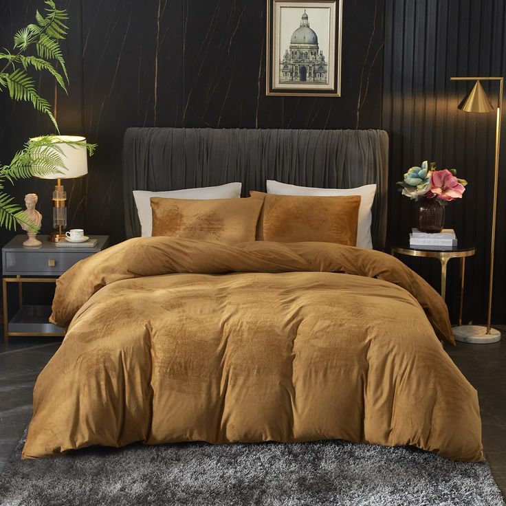 a bed with brown comforter and pillows in a black room next to a plant