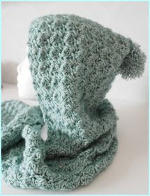 a crocheted hat and scarf sitting on top of a white table