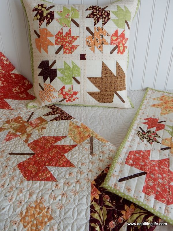 two quilted pillows sitting next to each other on a bed