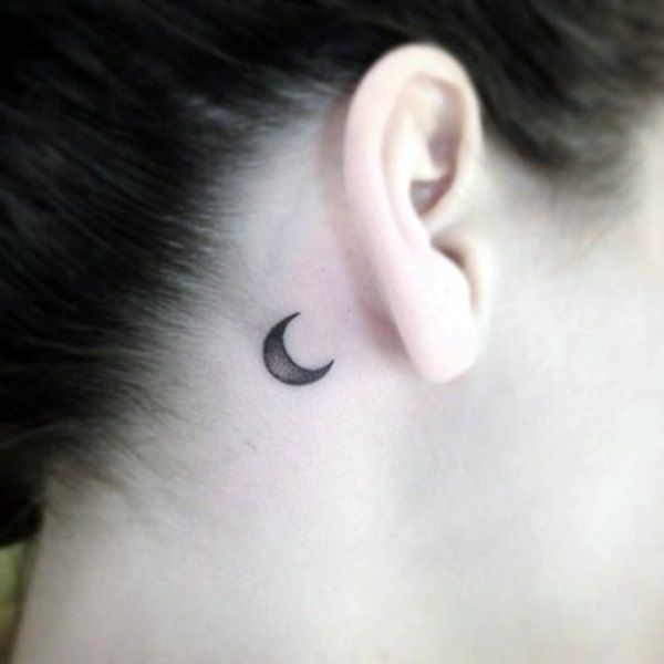 a woman with a small crescent tattoo on her ear