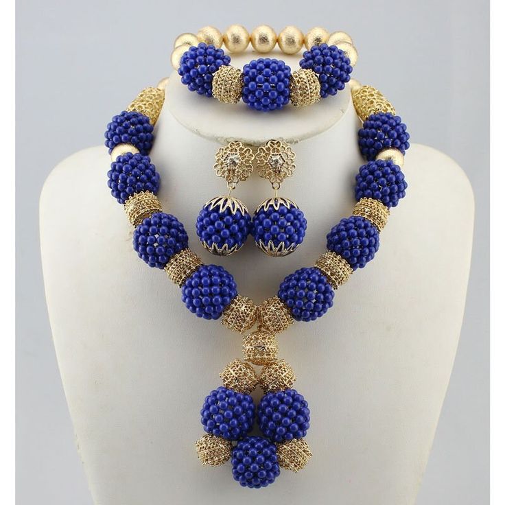 a blue and gold beaded jewelry set on a mannequin