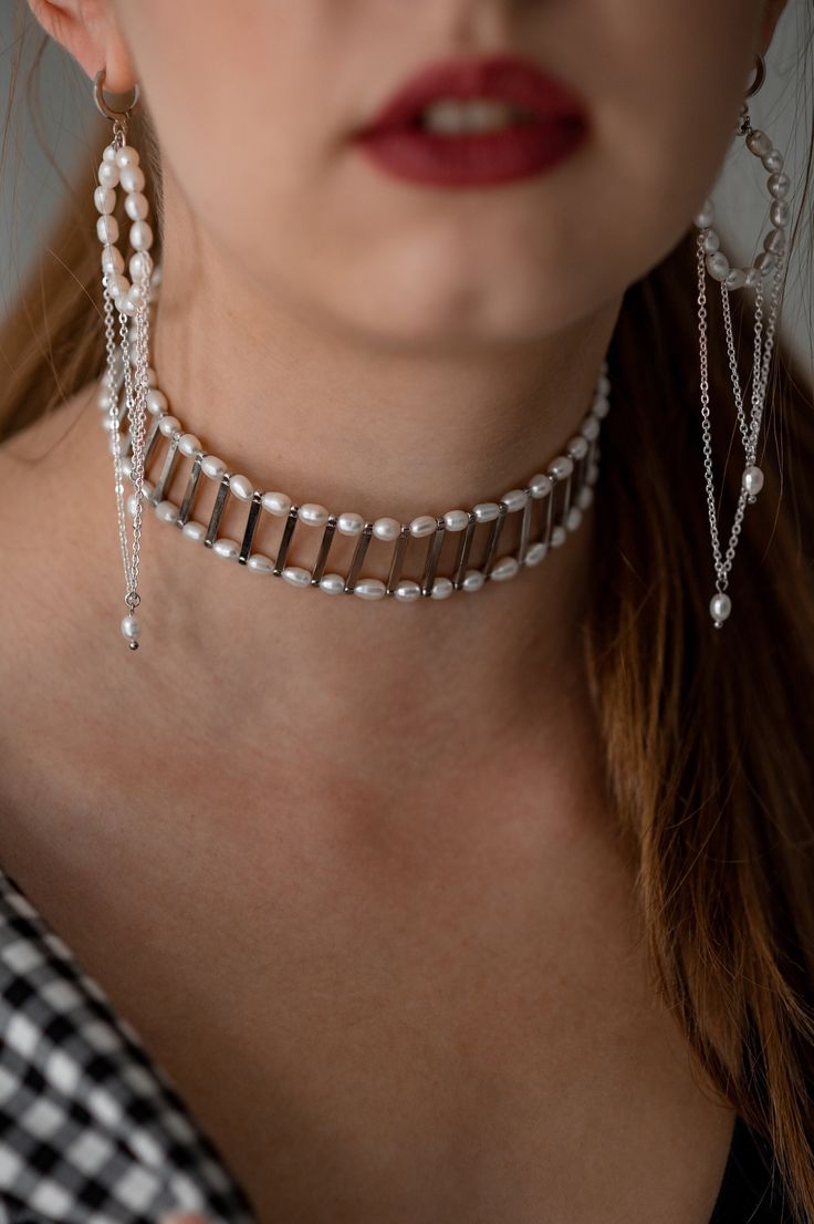 The choker is made of 2 rows of natural freshwater pearls and metal fittings in the form of sticks. The silver-colored fittings are made of jewelry stainless steel and brass. The choker will be a great gift for your girlfriend, wife, sister and yourself. Buy it for birthday, anniversary, graduation and wedding. JUST ONE SUCH NECKLACE QUALITY The high-quality materials I use in my jewelry are truly exceptional. They are carefully selected by me and come from trusted suppliers with whom I have a good relationship. Their timeless beauty and elegance make them an essential component of any jewelry collection. Whether it's a classic pearl necklace or a contemporary design, my high-quality pearls add sophistication and luxury to any outfit. View my entire shop here: https://www.etsy.com/shop/Tor White Metal Pearl Choker Necklace, Modern Silver Pearl Chain Necklace, Sterling Silver Pearl Chain Necklace For Party, Silver Pearl Bracelet With Pendant, Silver Pearl Chain Bracelet For Parties, Pearl Choker With Pearl Pendant In Silver, Silver Pearl Drop Choker Necklace, Silver Pearl Bracelet With Pearl Charm For Party, Silver Pearl Chain Choker Necklace