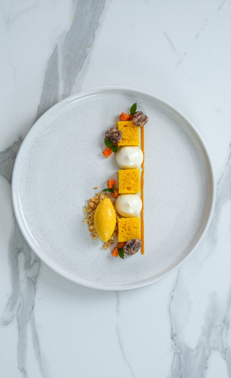 a white plate topped with food on top of a marble counter