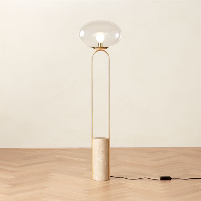 a floor lamp with a round glass shade on the base and a cord connected to it