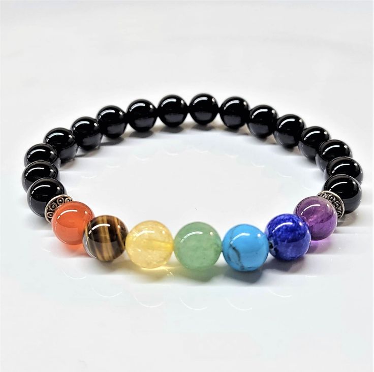 The Black Onyx with 7 Chakra Stones Bracelet is a powerful piece of jewelry that combines the grounding and protective energies of Black Onyx with the balancing and harmonizing properties of the seven chakra stones. This bracelet is designed not only for its aesthetic appeal but also for its profound metaphysical benefits, making it a popular choice among those seeking spiritual growth and energy alignment. Black Onyx: Metaphysical Properties Black Onyx is a powerful grounding stone known for its ability to absorb and transform negative energy, helping to prevent the drain of personal energy. It is associated with the root chakra, which is the foundation of our physical and spiritual energy. Here are the key metaphysical properties of Black Onyx: Protection: Black Onyx is renowned for its Black Spiritual Crystal Bracelet As Gift, Black Spiritual Beaded Bracelets For Meditation, Spiritual Black Crystal Bracelet Gift, Spiritual Black Crystal Bracelet As A Gift, Spiritual Black Bracelet With Round Beads, Multicolor Spiritual Bracelets With Black Beads, Spiritual Black Beads Crystal Bracelet For Healing, Spiritual Black Beaded Bracelets, Spiritual Black Beads Bracelet