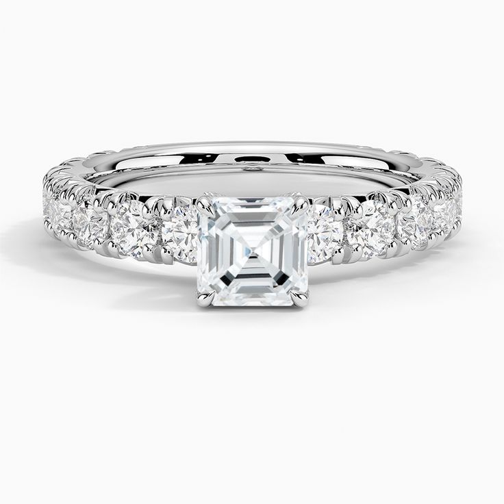 Asscher Cut Luxe Ellora Diamond Engagement Ring - 18K White Gold. This classic engagement ring features sparkling diamond accents that extend three-fourths of the way around the ring. A diamond adorned gallery and graceful claw prongs embrace the center gem (1 2/5 total carat weight). Timeless Asscher Cut Ring With Diamond Accents, Asscher Cut Diamond Promise Ring In Fine Jewelry Style, Asscher Cut Promise Ring In Fine Jewelry Style, Promise Ring With Asscher Cut Diamond Accents, Timeless Asscher Cut Diamond Ring, Refined Diamond Jewelry With Center Stone, Cubic Zirconia Diamond Ring, Asscher Cut For Promise, Cubic Zirconia Diamond Ring For Promise With Asscher Cut, Asscher Cut Diamond Wedding Ring With Diamond Accents