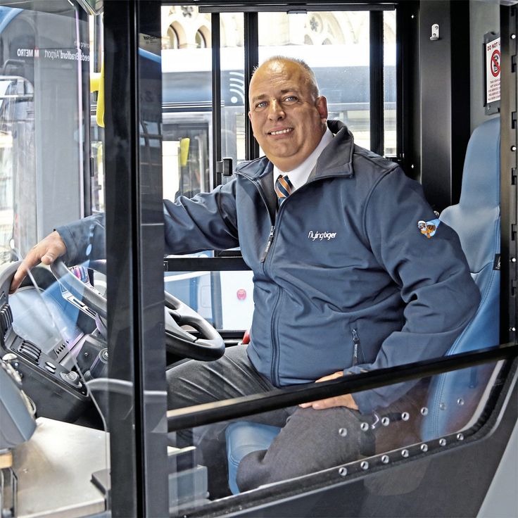 a man sitting in the driver's seat of a bus