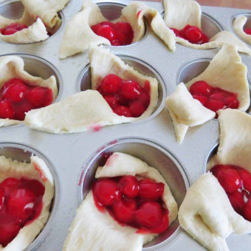 cupcakes with cherry filling in muffin tins ready to go into the oven