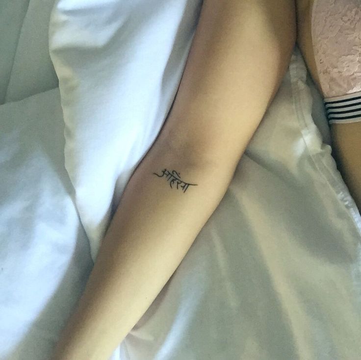 a person laying in bed with a tattoo on their arm that reads, i love you