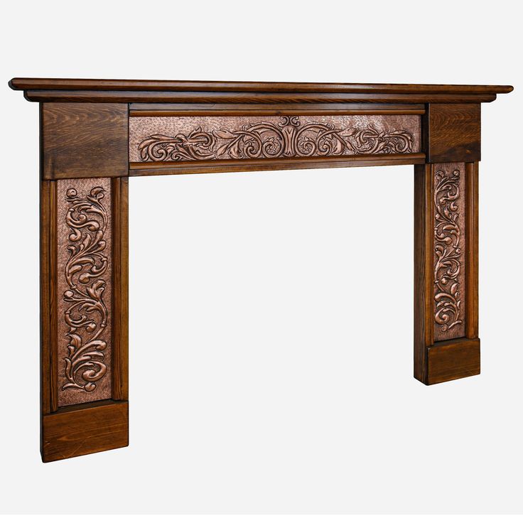 an ornate wooden fireplace mantel with carvings on the top and sides, in dark wood