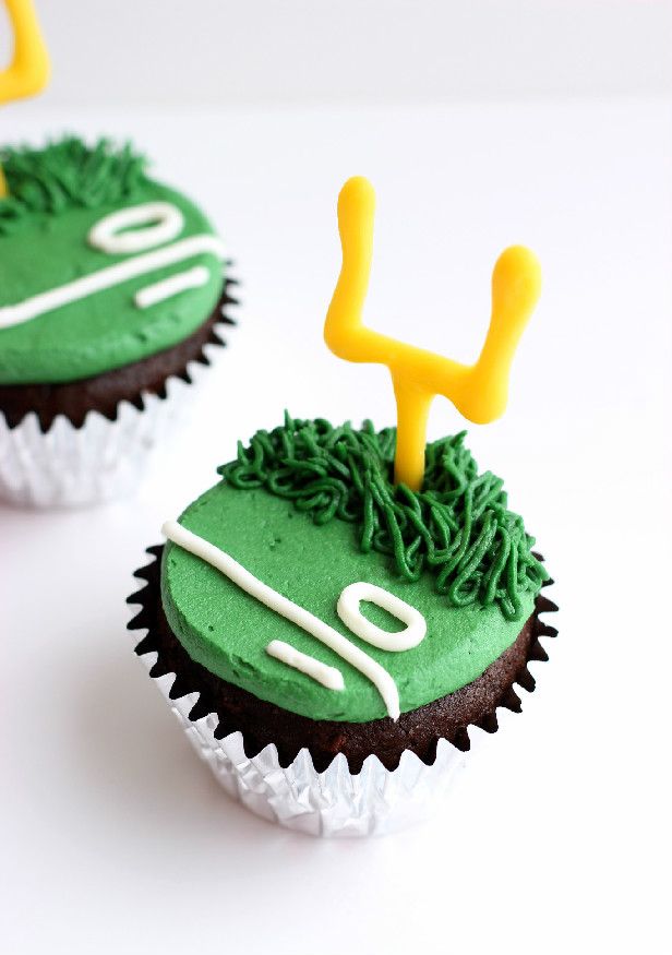 two cupcakes decorated with green frosting and yellow icing, the number forty