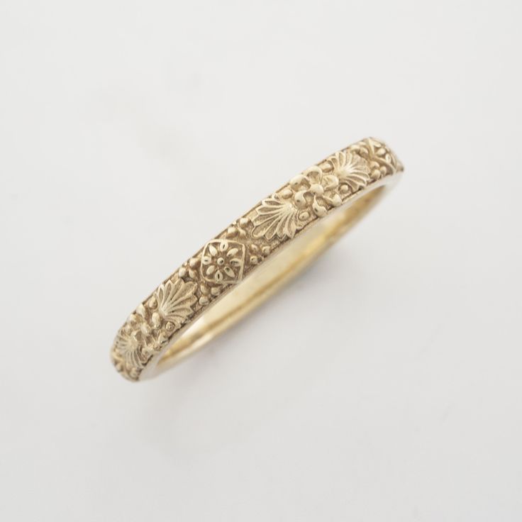 an antique yellow gold wedding ring with filigrees and leaves on the band