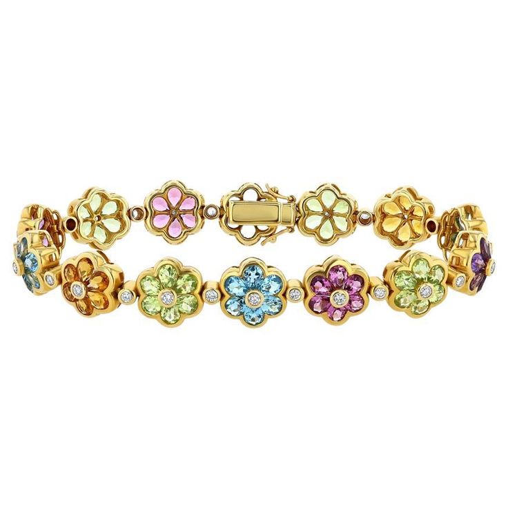 This vintage 18k yellow gold semi-precious gemstone and diamond bracelet is a vivacious homage to botanical divinity. In this bracelet vibrant gemstones come together with a bezel set diamond in the center to create an array of blue, orange, green, and purple flowers. These flowers are then linked to one another by a bezel set diamond, and ultimately come together to create a beauty which has stayed in excellent condition over time. (Diamonds: 28 — Round Brilliant Cut — 0.84 Carat, Gemstones (Ga Yellow Gold Diamond Bracelet With Gemstone Accents, Luxury Jeweled Yellow Gold Bracelets, Elegant Multicolor Gemstones With Bezel Setting, Elegant Multicolor Gemstones In Bezel Setting, Multicolor Gemstone Diamond Bracelet, Fine Jewelry Multicolor Gemstone Diamond Bracelet, Gift Yellow Gold Multi-stone Diamond Bracelet, Yellow Gold Multi-stone Diamond Bracelet Gift, Vintage Flower-shaped Gemstone Jewelry