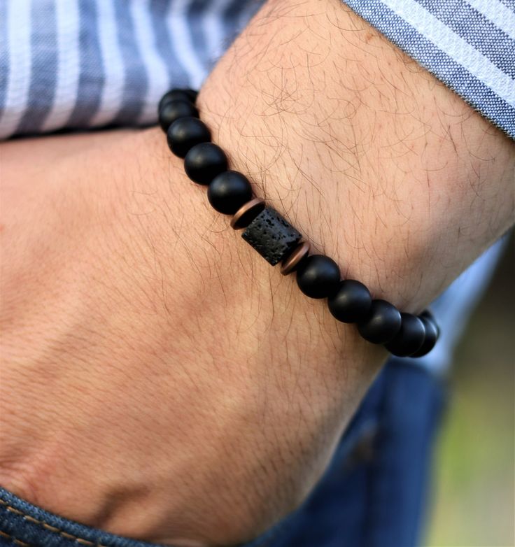 "Matte Black Onyx and  Cylinder Lava Bracelet,Balance Bracelet,Mens Bracelet,Stretch Bracelet,Gemstone Bracelet,Healing Bracelet,Men gifts    Discover the perfect blend of style and holistic benefits with our personalized men's bracelet featuring black onyx and cube lava gemstones. Meticulously crafted and tailored to fit your wrist size, this bracelet comes accompanied by a stunning wooden gift box, exquisitely engraved to your specifications. Black onyx, renowned for its potency, enhances inne Onyx Bracelets With Natural Stones For Gift, Onyx Bracelets With Natural Stones As Gifts, Spiritual Onyx Bracelets As Gift, Spiritual Onyx Bracelets For Gift, Hand-strung Onyx Bracelets As A Gift, Adjustable Black Wristband With Gemstone Beads, Hand-strung Obsidian Bracelet, Black Spiritual Bangle Jewelry, Spiritual Black Bangle Jewelry