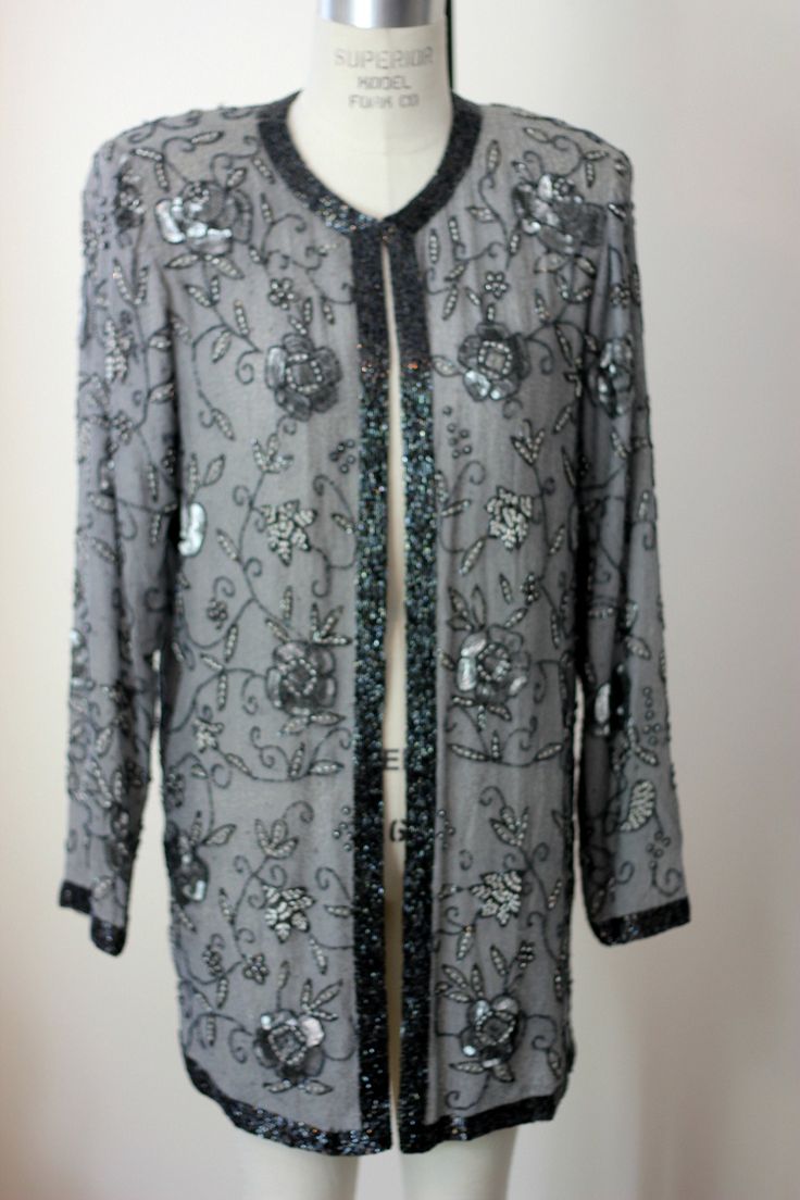 "A stunning Vintage Duster. This piece has no size tags, but it measures more like a small/medium. This is quite elegant and would be amazing for any special occasion. This piece is all silk with beading around the front and sleeves. There are also silver sequins that are throughout..Really unique and really a beauty! This is in Very good condition. I see only a few missing beads which is shown on image #8. It is a small area in the back that has a small strand of the patterned beading missing. Elegant Embellished Festive Outerwear, Elegant Holiday Sequin Outerwear, Elegant Embellished Outerwear For Party, Elegant Embellished Party Outerwear, Elegant Fitted Outerwear For Festive Occasions, Fall Wedding Embellished Outerwear, Elegant Holiday Party Outerwear, Elegant Festive Evening Outerwear, Fall Wedding Outerwear With Sequins