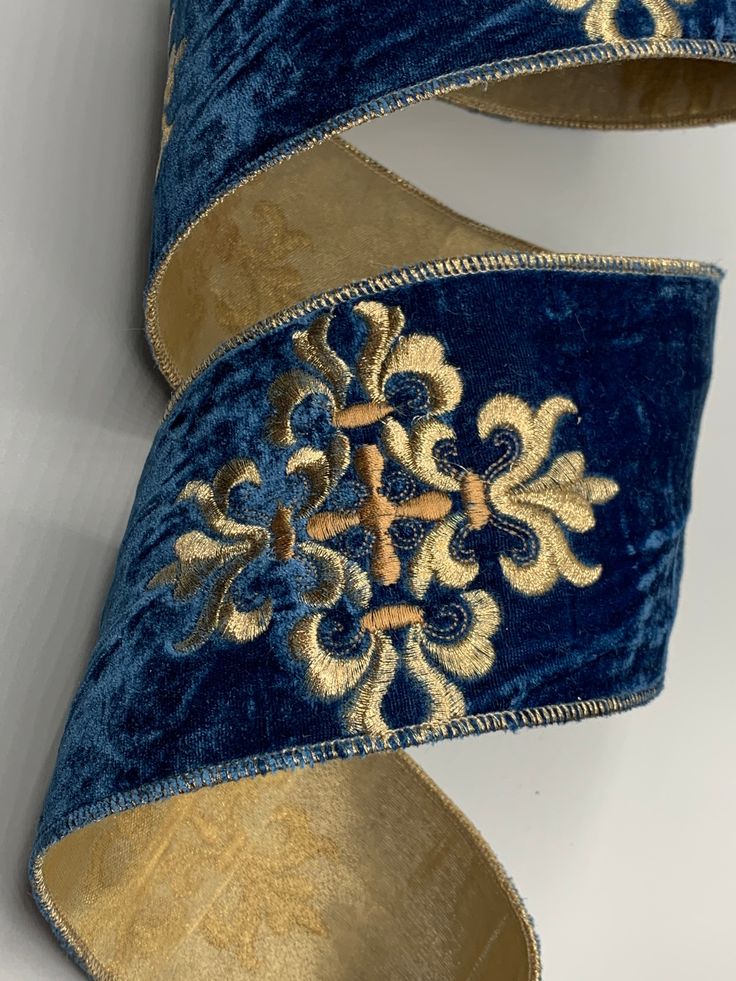 a pair of blue velvet shoes with gold accents