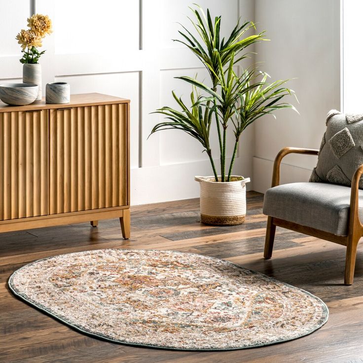 a living room with a rug, chair and potted plant