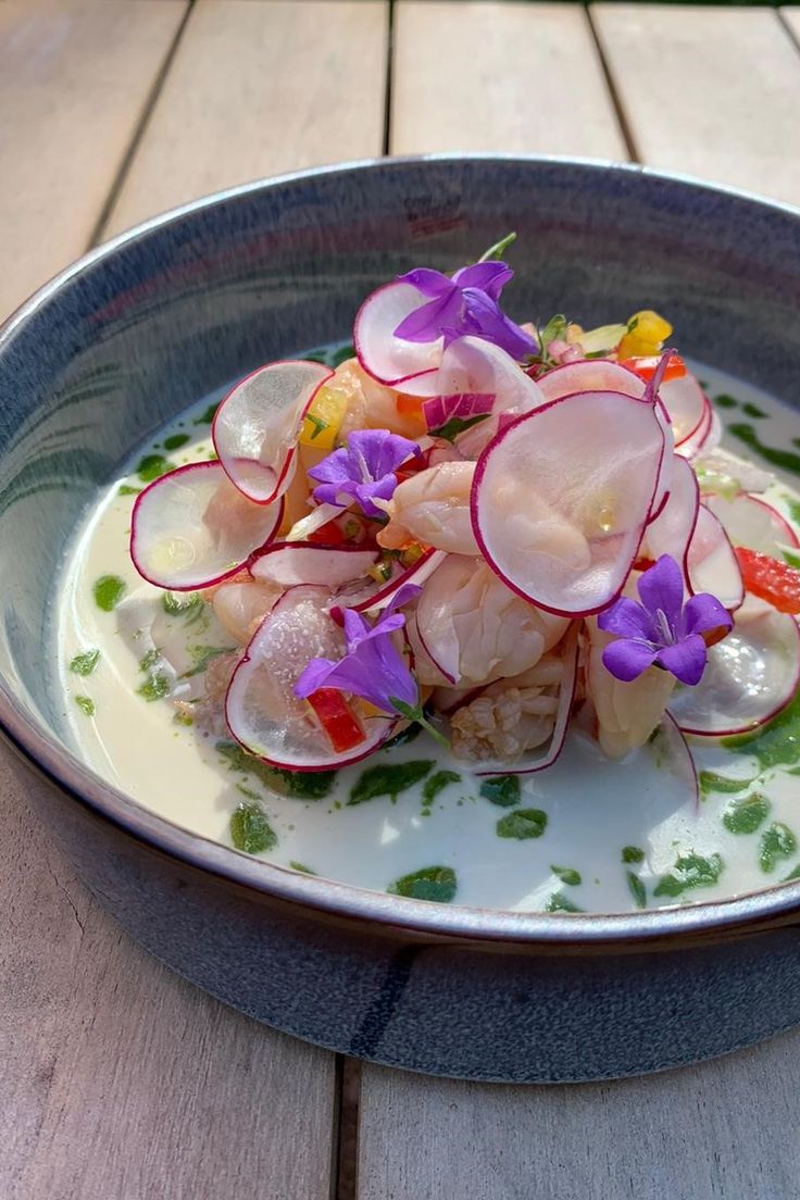 a blue bowl filled with food on top of a wooden table