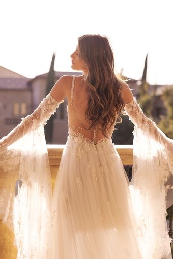 a woman in a wedding dress standing on a balcony