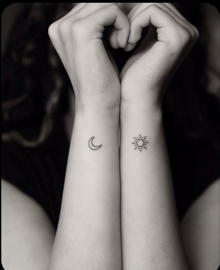 two small wrist tattoos with the sun and moon on each one side of their arms