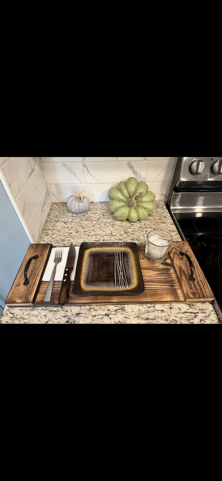 a kitchen counter top with utensils on it and a cutting board next to the stove