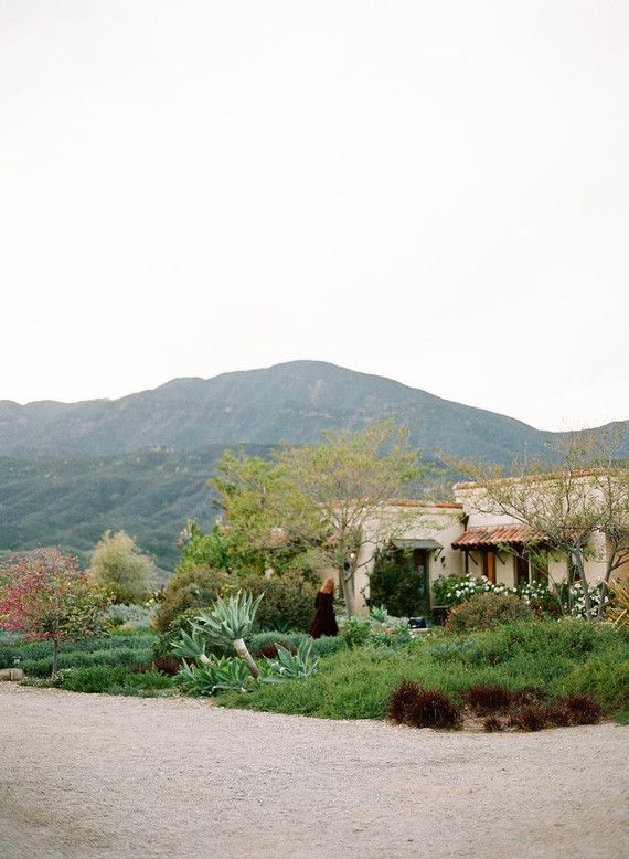 an old house with mountains in the background