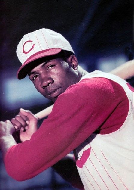 a baseball player holding a bat in his right hand and wearing a hat on top of his head