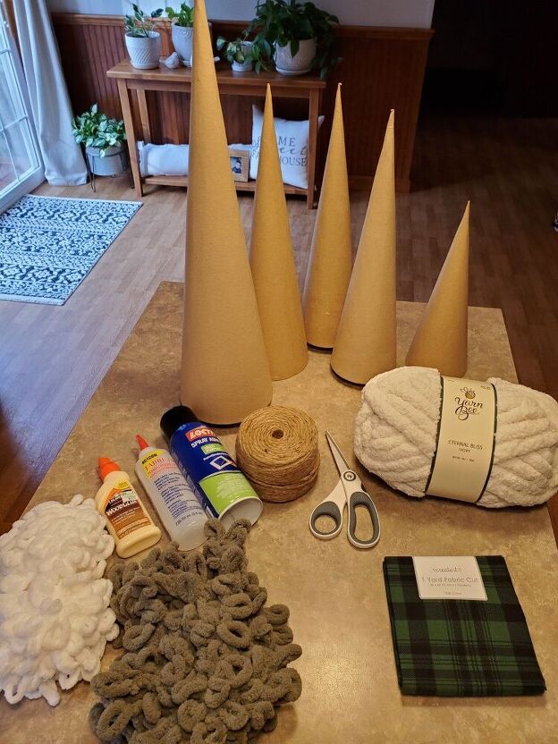 several cones, yarn, scissors and other crafting supplies on a table in a living room