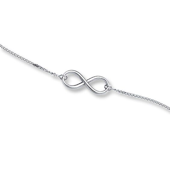 This elegant bracelet for her features an infinity symbol suspended between cable chains. Fashioned in 14K white gold, the bracelet adjusts from 7 to 7.5 inches in length, and secures with a lobster clasp. White Gold Infinity Bracelet For Formal Occasions, Formal White Gold Infinity Bracelet, Elegant Infinity Chain Bracelet With Adjustable Chain, Elegant Infinity Chain Bracelet Gift, Elegant Sterling Silver Infinity Chain Bracelet, Classic Sterling Silver Infinity Bracelet, Adjustable Silver Infinity Chain Bracelet, Sterling Silver Infinity Bracelets With Adjustable Chain, Silver Infinity Bracelet With Adjustable Chain