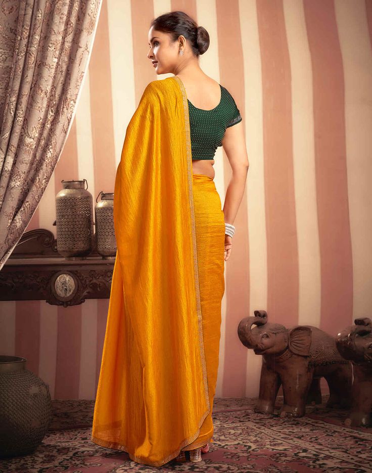 Turmeric Yellow Stone Work Embellished Silk Saree  Turmeric Yellow Stone Work Embellished Silk Saree is a luxurious and elegant piece. The rich silk fabric drapes beautifully, creating a flowing and sophisticated look. The intricate stone work, which can feature floral motifs, geometric patterns, or abstract designs, adds a touch of opulence and sparkle.  Features Of Turmeric Yellow Stone Work Embellished Silk Saree  Traditional Handloom Craft  Intricate Gold Brocade Work  Durability and Longevi Gold Floor-length Pre-draped Saree With Cutdana, Festive Yellow Raw Silk Pre-draped Saree, Bollywood Style Slub Silk Blouse With Sheer Dupatta, Gold Tussar Silk Sharara For Designer Wear, Gold Slub Silk Sharara For Festivals, Traditional Drape Slub Silk Blouse Piece With Zari Work, Traditional Slub Silk Blouse Piece With Sheer Dupatta, Elegant Slub Silk Pre-draped Saree With Zari Work, Elegant Yellow Pre-draped Saree With Traditional Drape