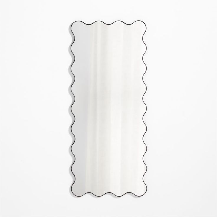 a mirror with scalloped edges on a white wall in the shape of a rectangle