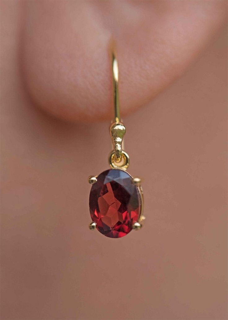 Our Garnet Dangle Earrings in gold vermeil are just the right size to be noticed and small enough to wear all day comfortably. The stone is a large 8mm natural deep red genuine Garnet popular as a January birthstone. Also available in sterling silver, see earrings section. Sold as a pair, comes with extra silicone ear backs to keep them secure. DETAILS * Dimensions: 8mm x 6mm, total length - 24mm * Material: 18k gold vermeil over 925 sterling silver base, genuine Garnet * Birthstone month - Janu Garnet Earrings Gold, Red Dangle Earrings, Gemstone Earrings Dangle, Garnet Birthstone, Drop Earrings Gold, Cut Earrings, Garnet Jewelry, January Birthstone, Garnet Earrings