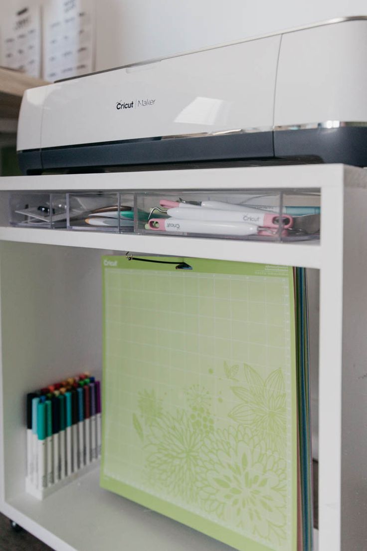 a machine that is sitting on top of a shelf next to some papers and pens