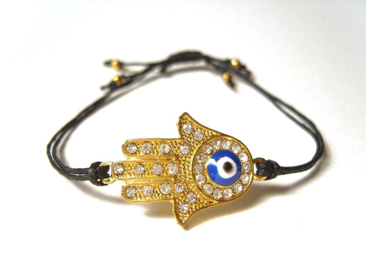 A cute string bracelet featuring the Hand of Fatima.  This pretty gold plated charm depicts an open palm, the Hand of Fatima.  Known in some cultures as the Hamsa, the Hand Of Fatima is thought to provide protection and good luck to those who carry it with them!  This particular charm has little diamantes set within it and also features the evil eye symbol.  The charm is suspended on a black, 100% cotton cord which has been tied in such a way as to have an adjustable fastening.  Slip the bracele Black String Bracelet, Seahorse Jewelry, Oversized Hoop Earrings, Evil Eye Hamsa, Hamsa Jewelry, Black Hoops Earrings, Good Luck Bracelet, Hamsa Bracelet, Hamsa Charm