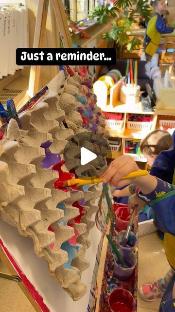 a young boy is painting an egg shell with paint and paper machs on it