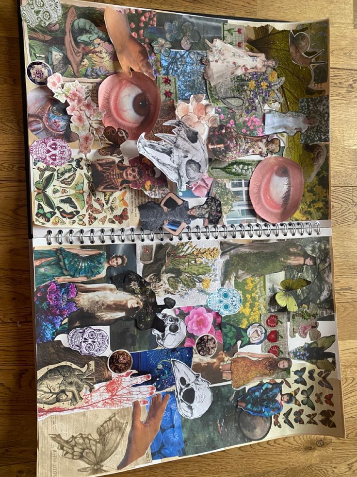 an open notebook covered in stickers and pictures on a wooden table with wood flooring