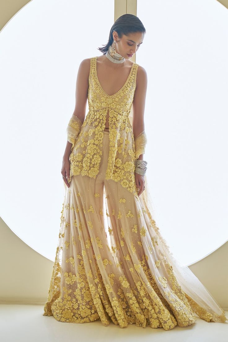 Shop for these amazing collections of Yellow Net Embroidery Sequins Deep V Flower Peplum Tunic Sharara Set For Women by Seema Gujral online at Aza Fashions.