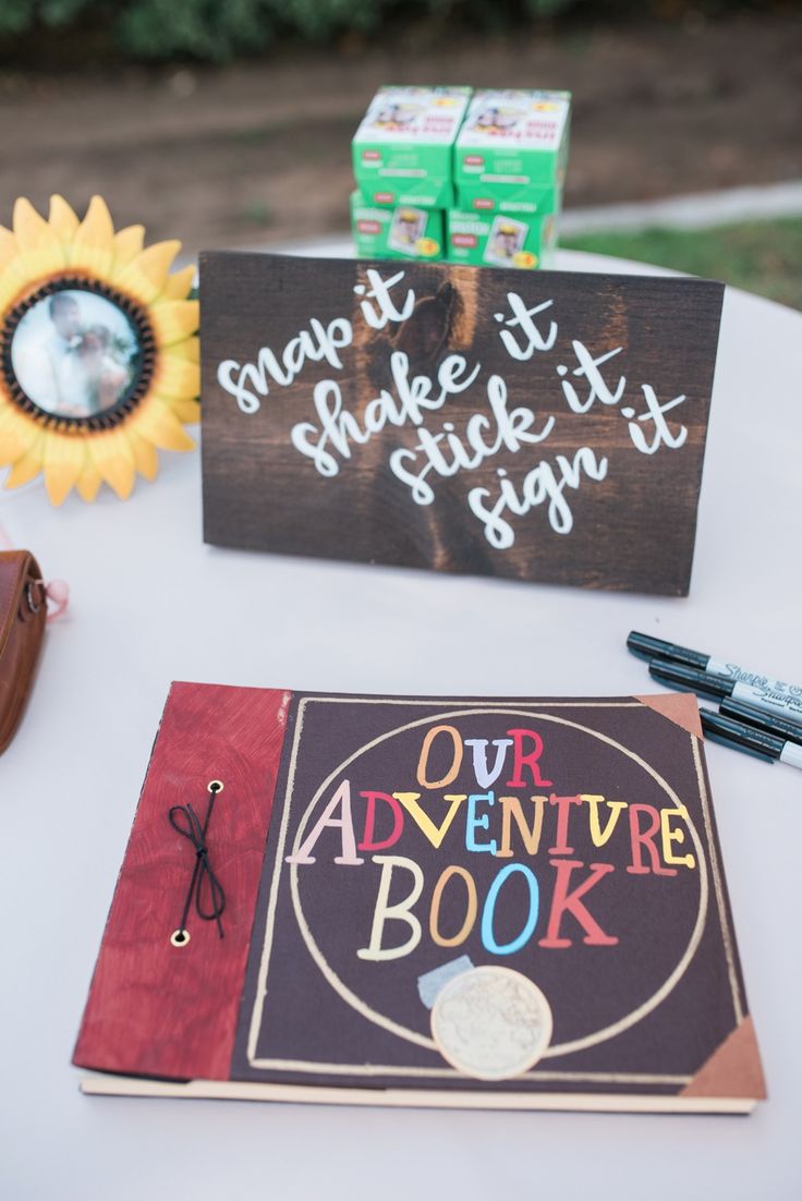 a sign that is sitting on top of a table next to a book and some pens