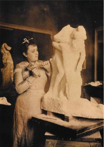 an old black and white photo of a woman working on a statue in a studio