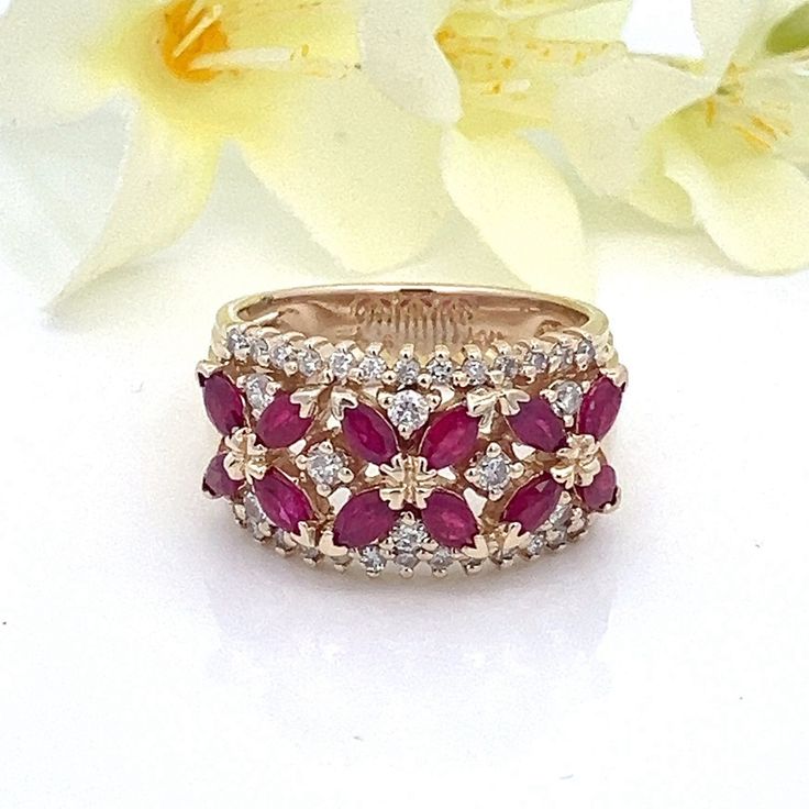 This beautiful ring contains genuine marquise cut rubies and natural white diamonds.  The mounting is solid 14k yellow gold. There are 34 diamonds set in the ring, along with 12 rubies.  The band is nice and thick, and can easily be sized.   Ring Size: 7- can be sized  Metal Content: Solid 14k Yellow Gold Gemstones: 12 Marquise Cut Rubies Carat: .60 ctw Diamonds: Natural/Genuine 34 Round Brilliant Cut  Carat: 0.44 ctw Clarity: I1 Color:  G Ring Face (North/South): 12mm Height of ring off of finger: 4mm Ring shank width: 5mm Weight: 7.4 Grams Stamps: 14k Condition: Excellent Estate Condition Items will ship in a gift box or pouch Each piece is thoroughly examined and refinished as needed by our professional jewelers, tested to guarantee metal content,  graded by our in-house GIA (Gemologica Marquise Red Diamond Ring, Gold Marquise Ruby Ring With Diamonds, Marquise Ruby And Diamond Multi-stone Ring, Red Marquise Ring With Diamond Accents, Red Marquise Diamond Accent Rings, Red Marquise Rings With Diamond Accents, Marquise Cut Ruby Jewelry With Rose Cut Diamonds, Marquise Ruby Ring With Diamond Accents In Yellow Gold, Red Marquise Cut Rings With Diamond Accents