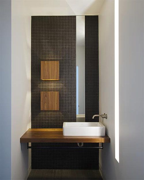 a bathroom with a sink, mirror and wooden counter top in it's corner