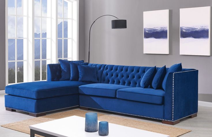 a living room with blue couches and pictures on the wall above it, along with a coffee table