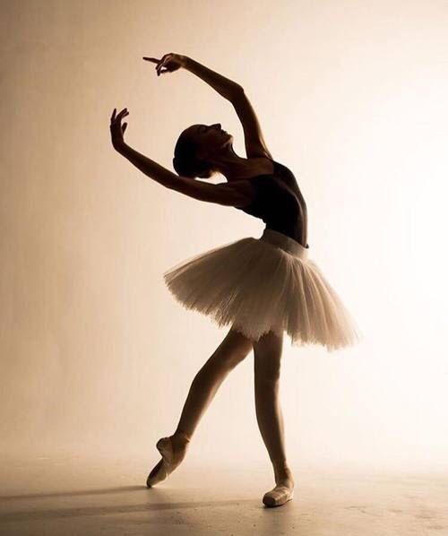 a young ballerina in a white tutu and black leotard