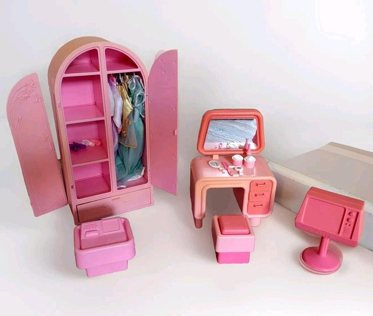 a doll's dressing room with pink furniture and accessories