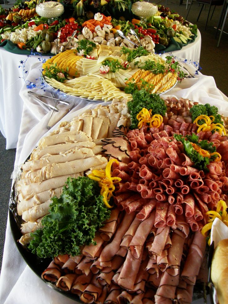 an assortment of meats and vegetables on a buffet table