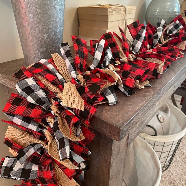 a red and black plaid bow sitting on top of a wooden table next to baskets